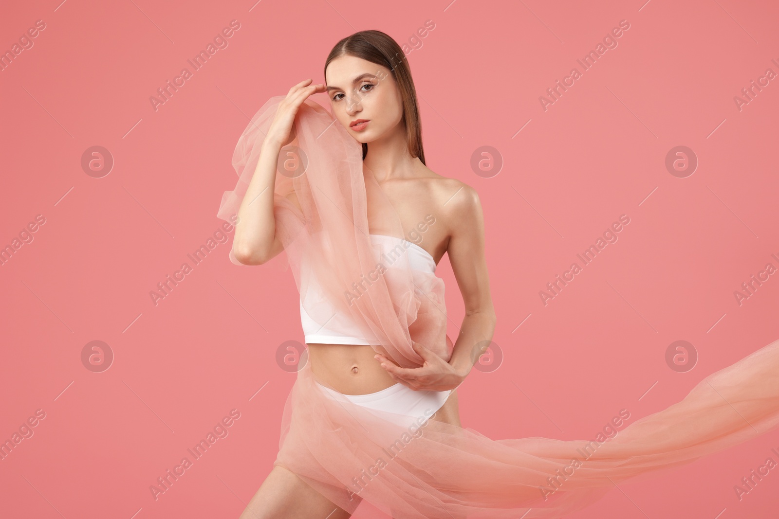 Young woman with beautiful fabric on pink background Photo of Young woman with beautiful fabric on pink background