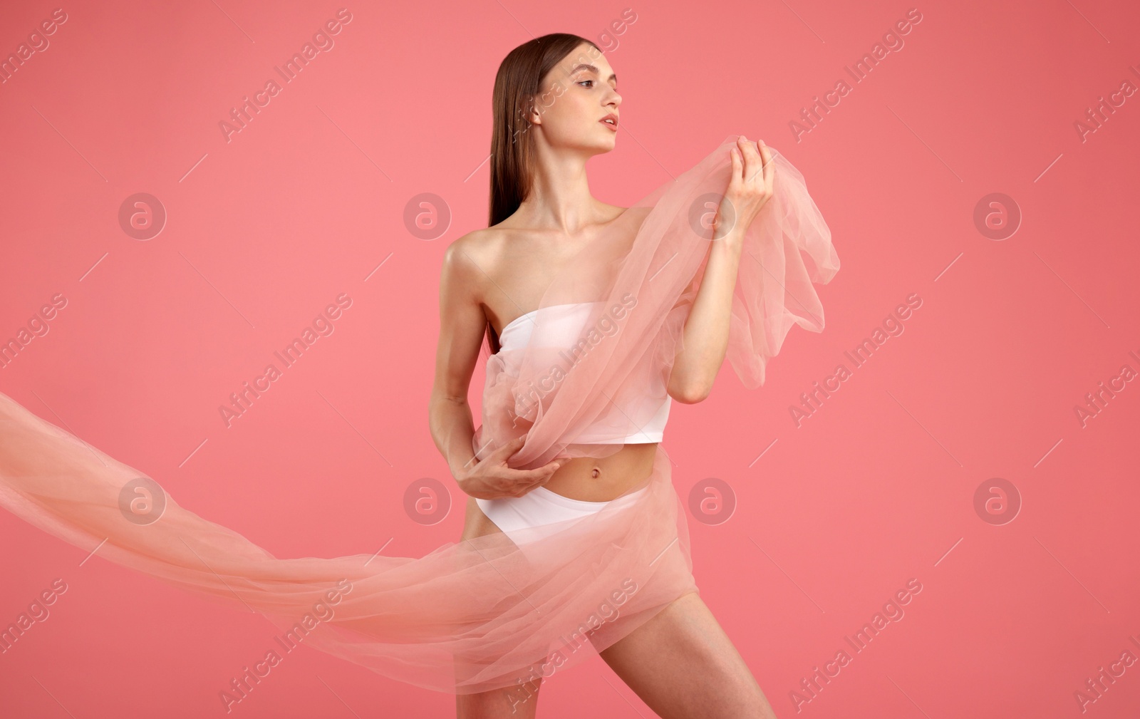 Young woman with beautiful fabric on pink background Photo of Young woman with beautiful fabric on pink background