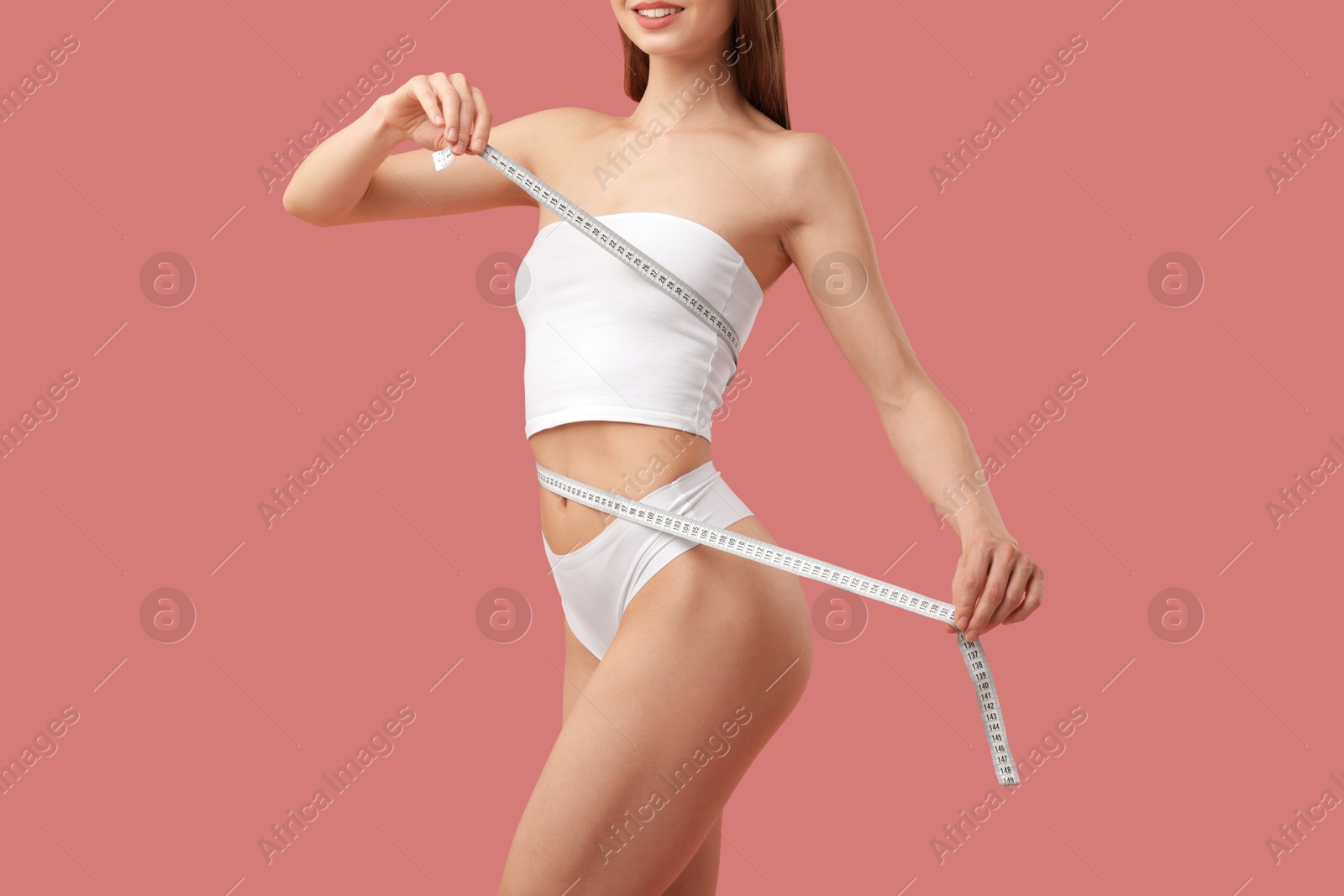 Woman with slim body and measuring tape on pink background, closeup Photo of Woman with slim body and measuring tape on pink background, closeup