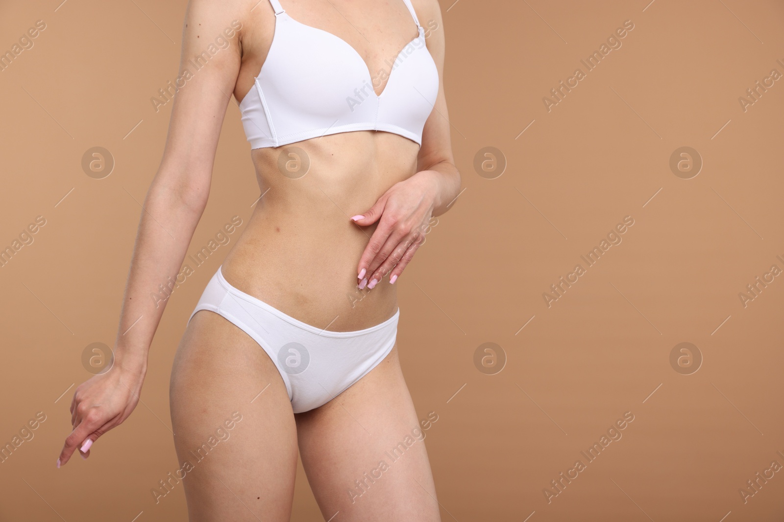 Woman with perfect slim body on beige background, closeup. Space for text Photo of Woman with perfect slim body on beige background, closeup. Space for text