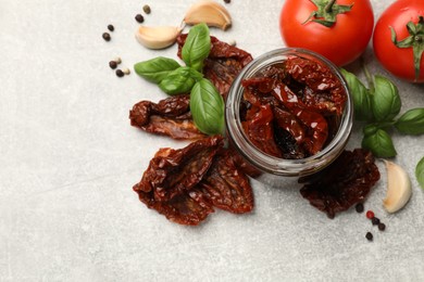 Photo of Delicious sun dried tomatoes, fresh vegetables and spices on grey table, flat lay. Space for text