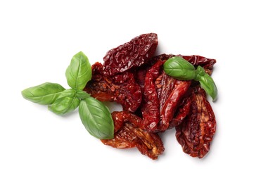 Photo of Delicious sun dried tomatoes and basil isolated on white, top view