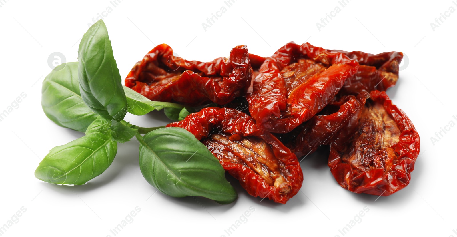 Delicious sun dried tomatoes and basil isolated on white Photo of Delicious sun dried tomatoes and basil isolated on white