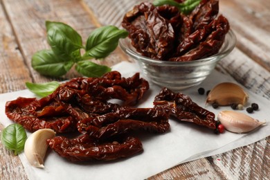 Photo of Delicious sun dried tomatoes and spices on wooden table, closeup
