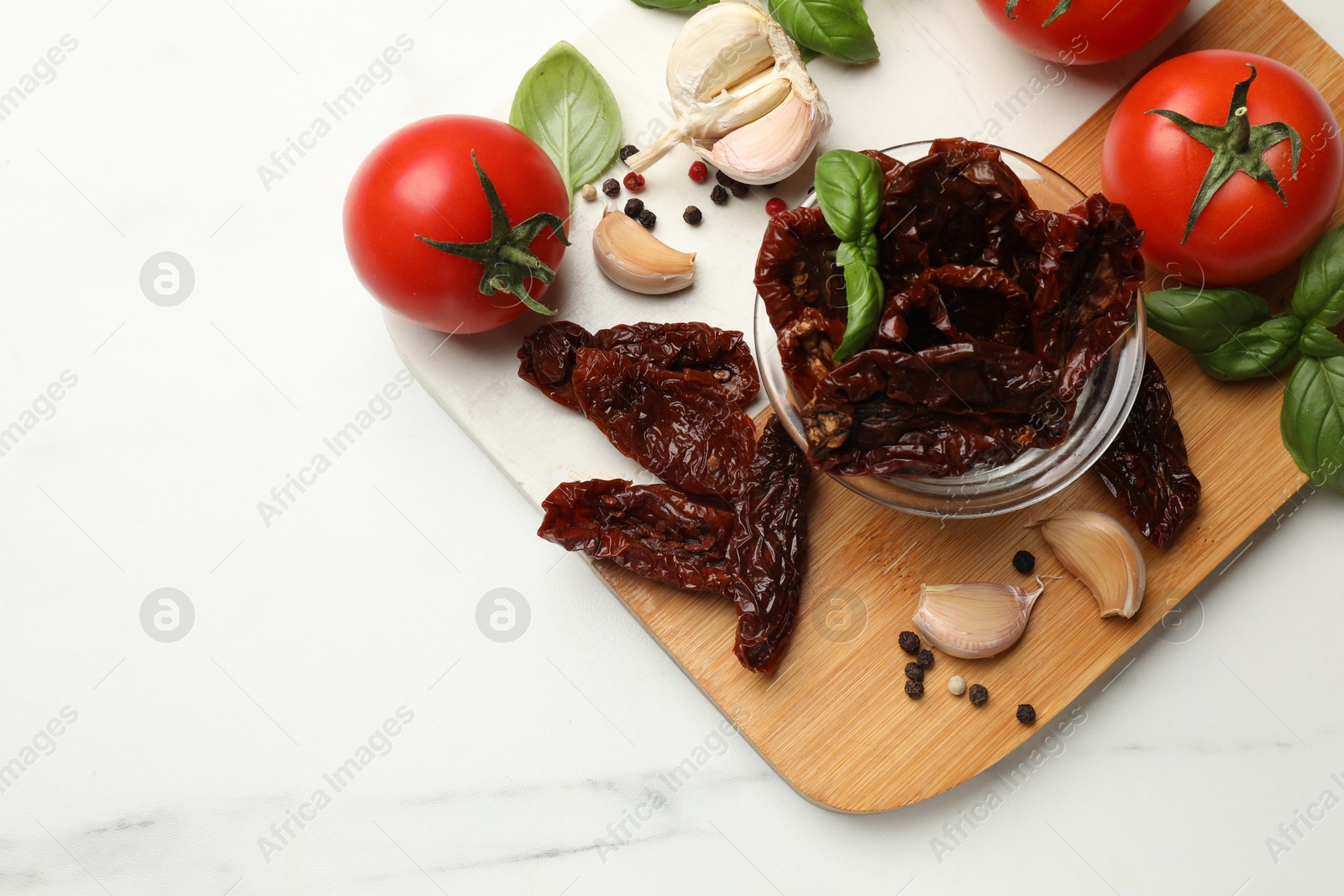 Delicious sun dried tomatoes, fresh vegetables and spices on white marble table, top view. Space for text Photo of Delicious sun dried tomatoes, fresh vegetables and spices on white marble table, top view. Space for text