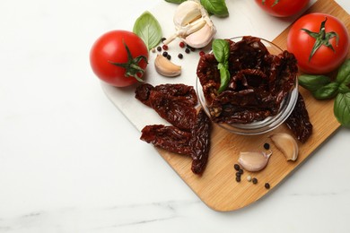 Photo of Delicious sun dried tomatoes, fresh vegetables and spices on white marble table, top view. Space for text