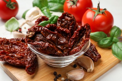 Photo of Delicious sun dried tomatoes, fresh vegetables and spices on table, closeup