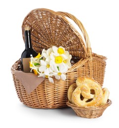 Photo of Picnic wicker basket with beautiful flowers, bottle of wine and pretzels isolated on white