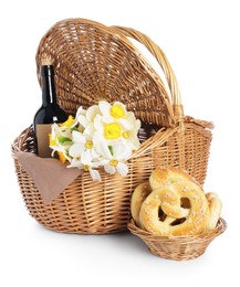 Photo of Picnic wicker basket with beautiful flowers, bottle of wine and pretzels isolated on white