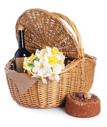 Photo of Picnic wicker basket with beautiful flowers, bottle of wine and cake isolated on white