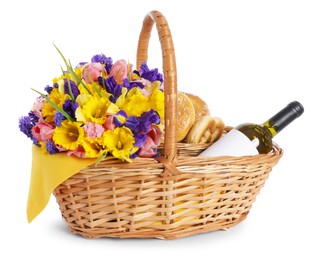 Photo of Picnic wicker basket with beautiful flowers, bottle of wine and pretzels isolated on white