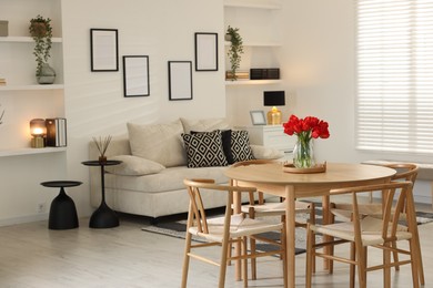 Photo of Beautiful red tulips in vase on wooden table indoors, space for text
