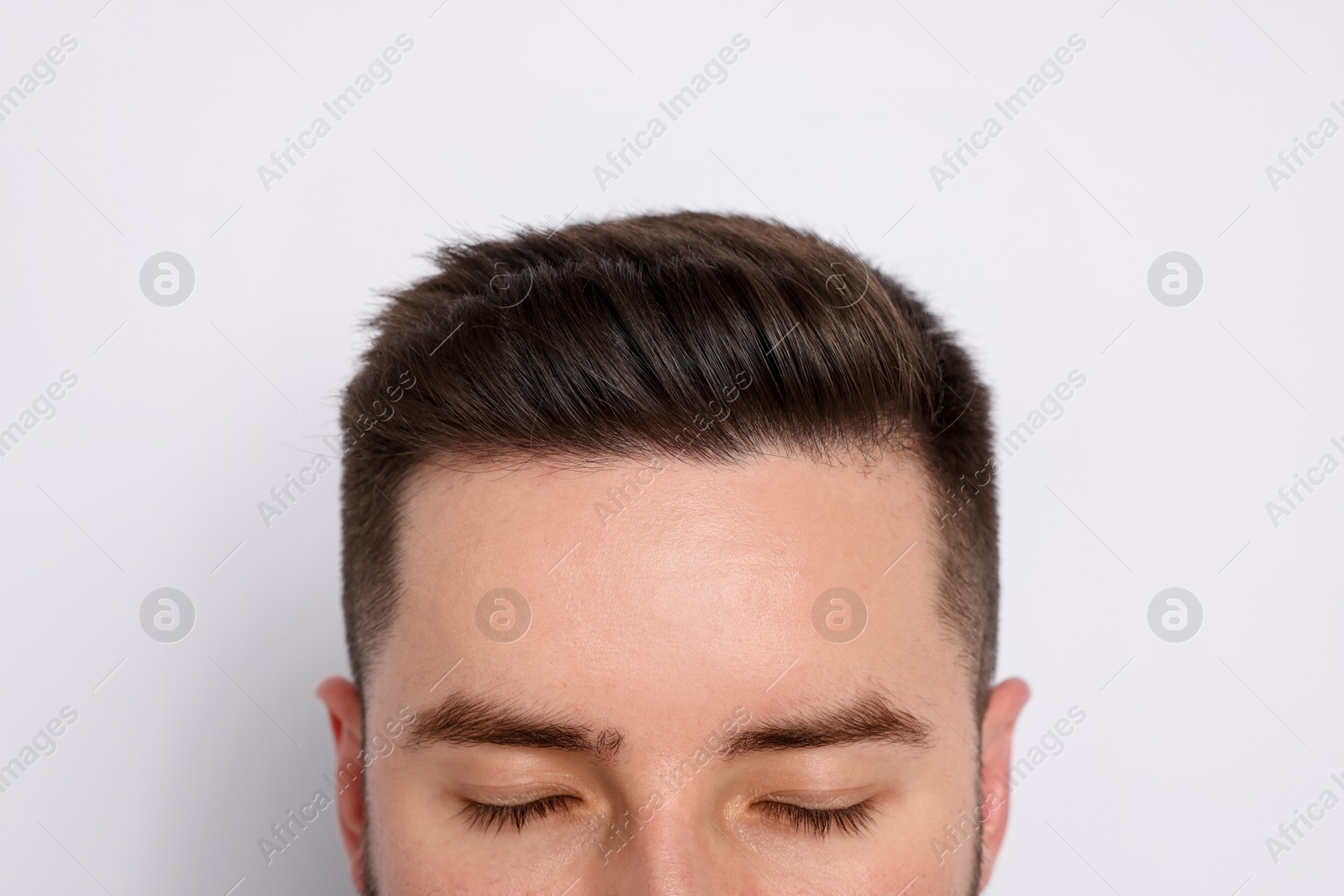 Man after hair loss treatment on light background, closeup Photo of Man after hair loss treatment on light background, closeup