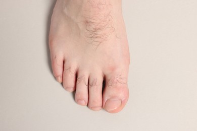 Photo of Barefoot man on light grey background, top view