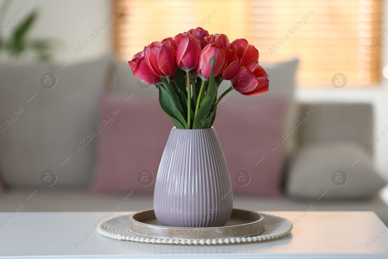 Photo of Beautiful tulips in vase on white table indoors