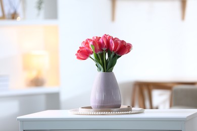 Photo of Beautiful tulips in vase on white table indoors