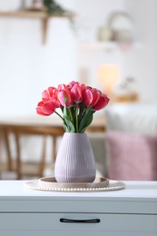 Photo of Beautiful tulips in vase on white table indoors