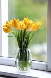 Photo of Beautiful tulips in vase on window sill