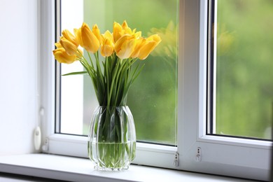 Photo of Beautiful tulips in vase on window sill