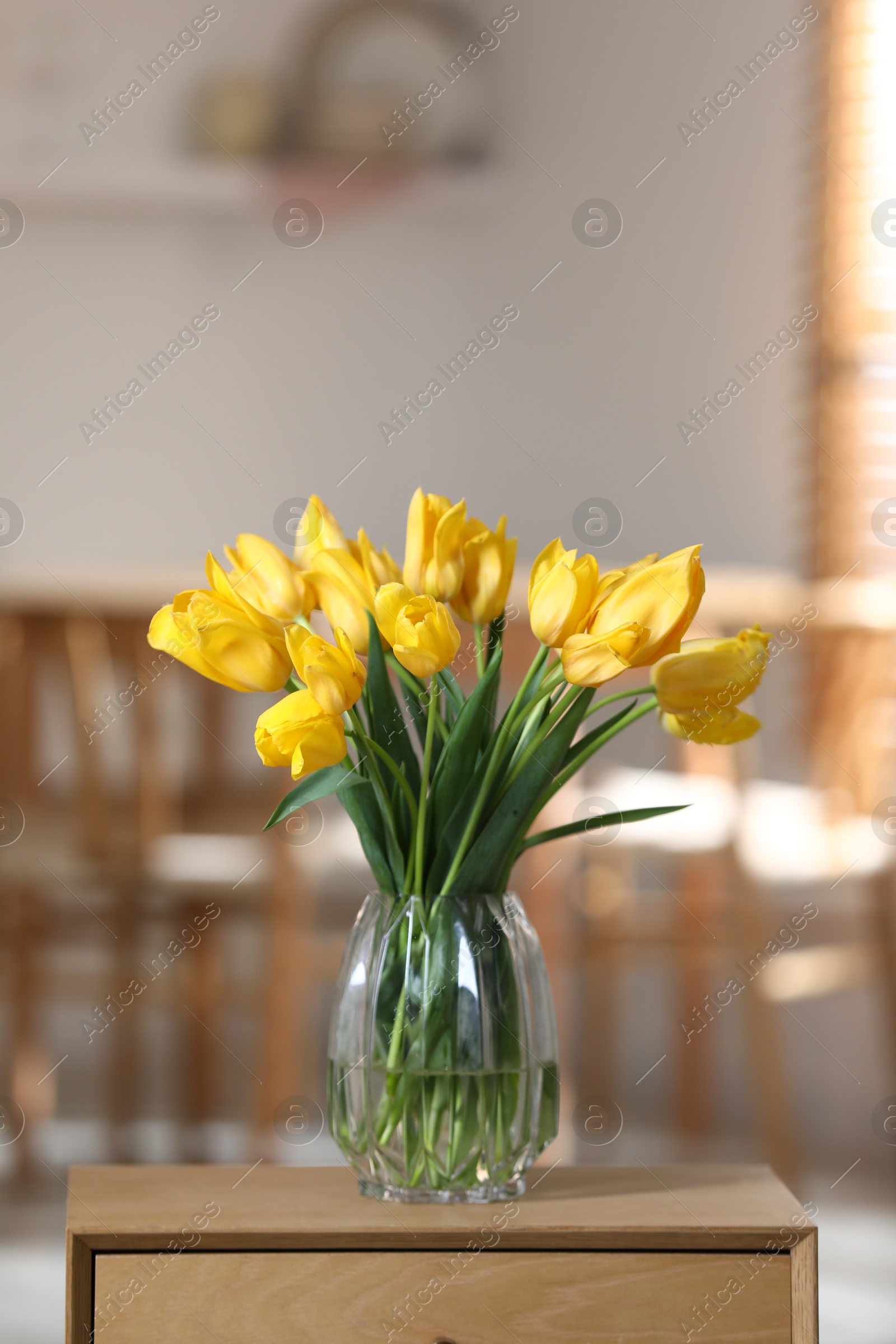 Photo of Beautiful tulips in vase on wooden table indoors. Space for text