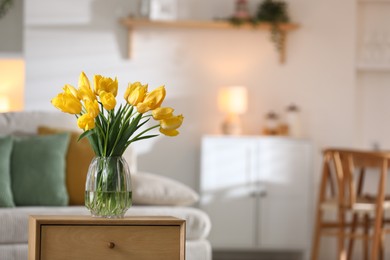Photo of Beautiful tulips in vase on wooden table indoors. Space for text