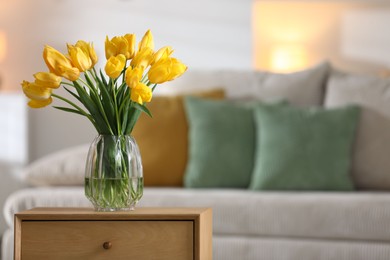 Photo of Beautiful tulips in vase on wooden table indoors. Space for text