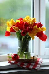Photo of Beautiful tulips in vase on window sill
