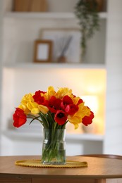 Photo of Beautiful tulips in vase on wooden table indoors. Space for text