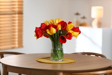 Photo of Beautiful tulips in vase on wooden table indoors