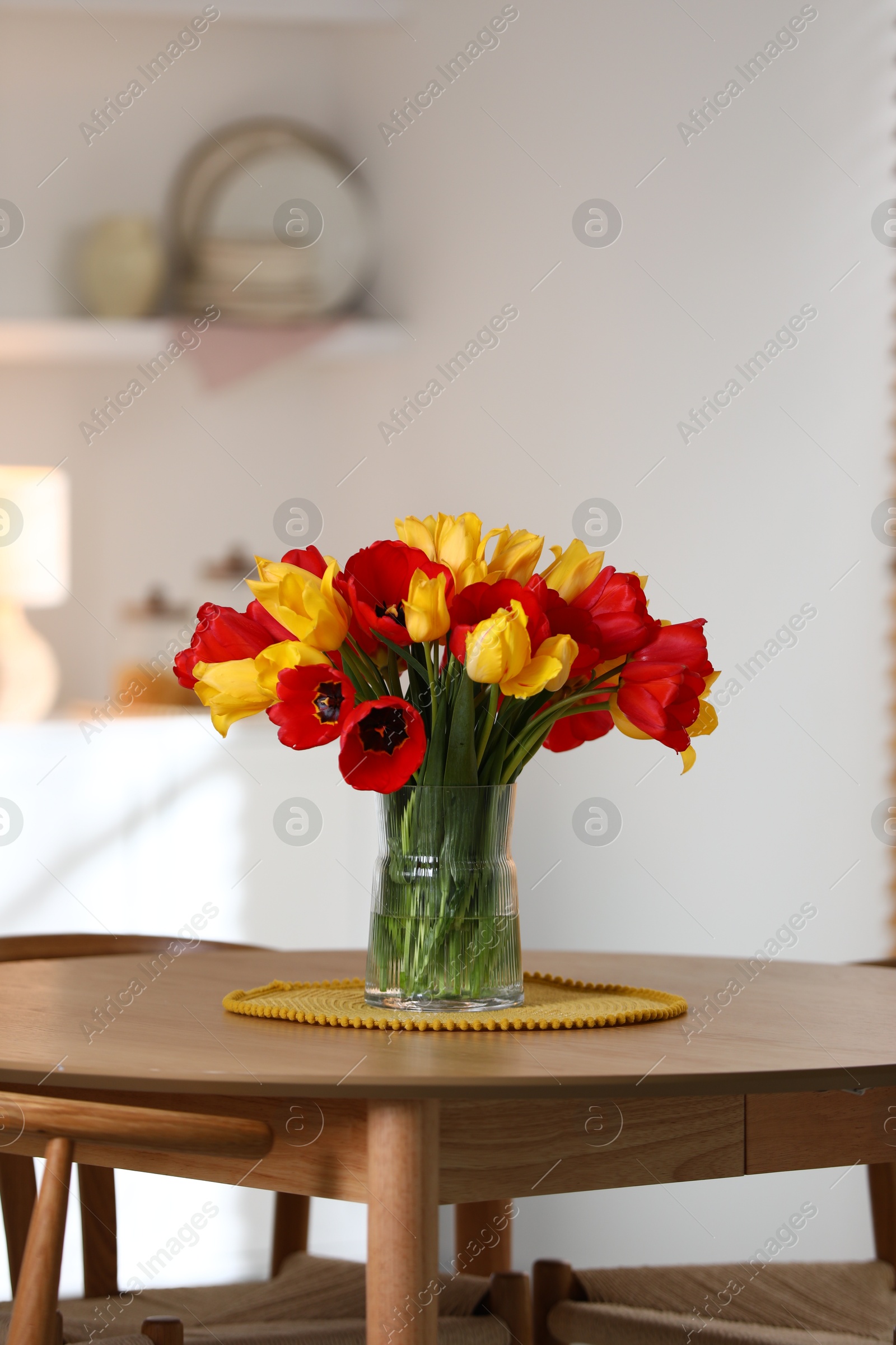 Photo of Beautiful tulips in vase on wooden table indoors. Space for text