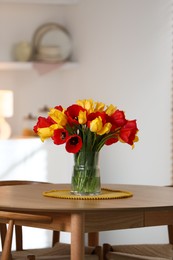 Photo of Beautiful tulips in vase on wooden table indoors. Space for text