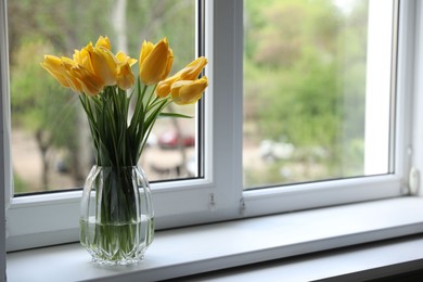 Photo of Beautiful tulips in vase on window sill. Space for text