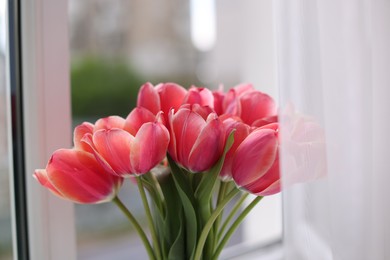 Photo of Bouquet of beautiful tulips near window indoors, closeup