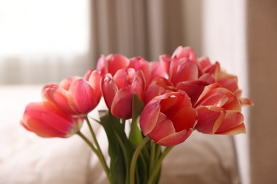 Photo of Bouquet of beautiful tulips in bedroom, closeup