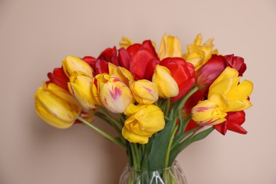 Photo of Bouquet of beautiful tulips on beige background, closeup