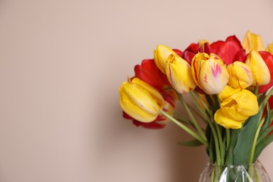 Photo of Bouquet of beautiful tulips on beige background, closeup. Space for text