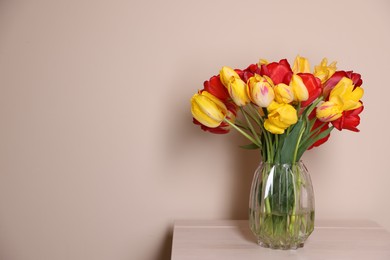 Photo of Bouquet of beautiful tulips on table against beige background. Space for text