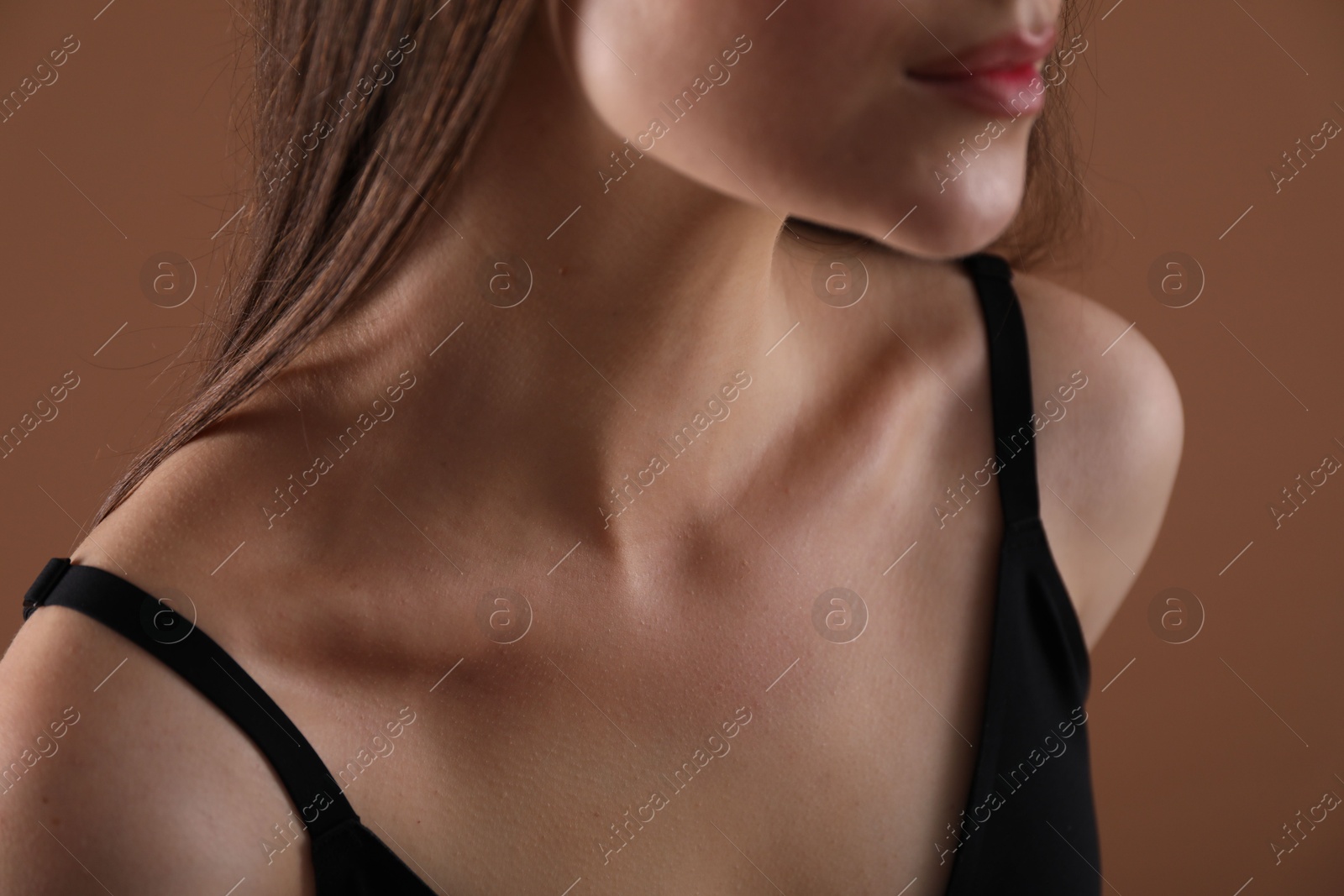 Woman with beautiful collarbone on brown background, closeup Photo of Woman with beautiful collarbone on brown background, closeup