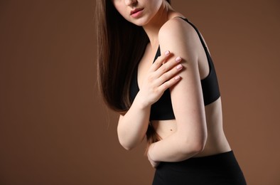 Photo of Woman with beautiful body on brown background, closeup. Space for text