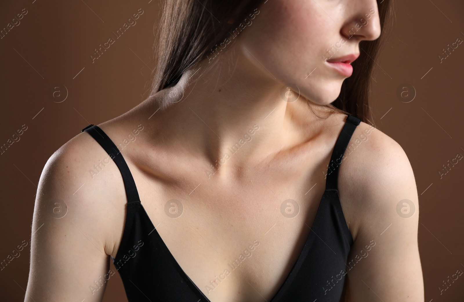 Woman with beautiful collarbone on brown background, closeup Photo of Woman with beautiful collarbone on brown background, closeup