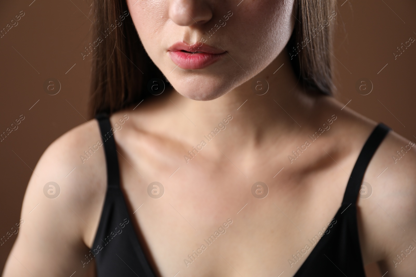 Woman with beautiful collarbone on brown background, closeup Photo of Woman with beautiful collarbone on brown background, closeup