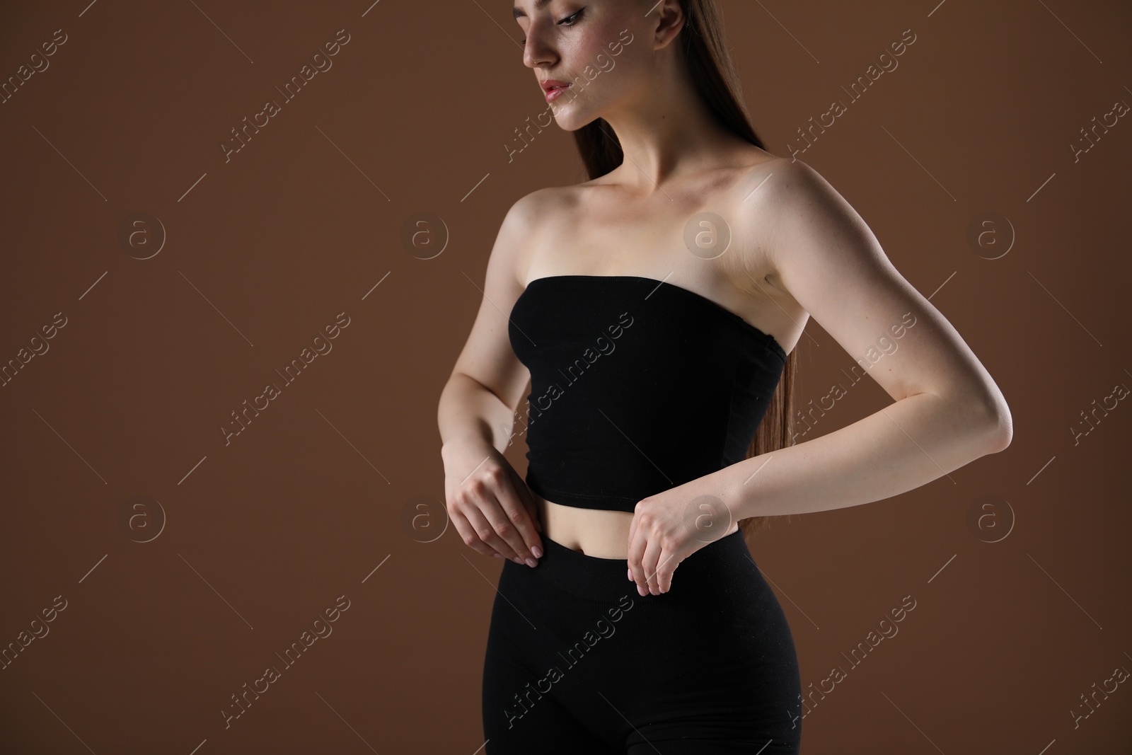 Woman with beautiful body on brown background, closeup. Space for text Photo of Woman with beautiful body on brown background, closeup. Space for text