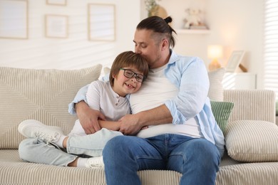 Photo of Father with his son on sofa at home