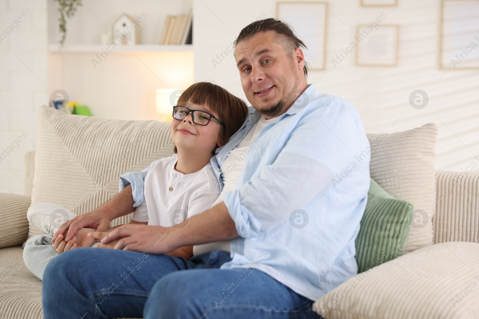 Father with his son on sofa at home Photo of Father with his son on sofa at home