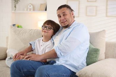 Photo of Father with his son on sofa at home