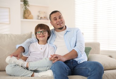 Photo of Father with his son on sofa at home