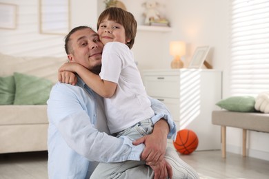 Photo of Portrait of father and his son at home, space for text