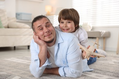 Photo of Father and his son on floor at home