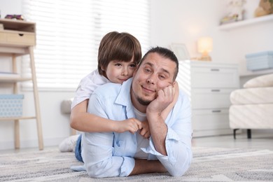 Photo of Father and his son on floor at home