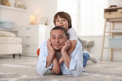 Photo of Father and his son on floor at home